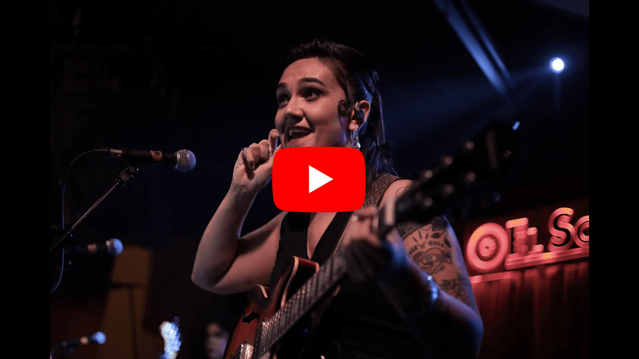 La cantante de Los Jaleo con guitarra en el escenario de la sala El Sol